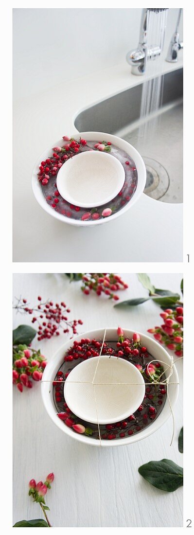 An ice bowl being prepared; the ice contains hypericum and Skimmia japonica berries