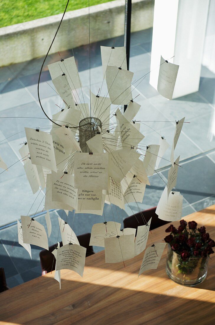 Ingo Maurer paper notes lamp hanging above dining table