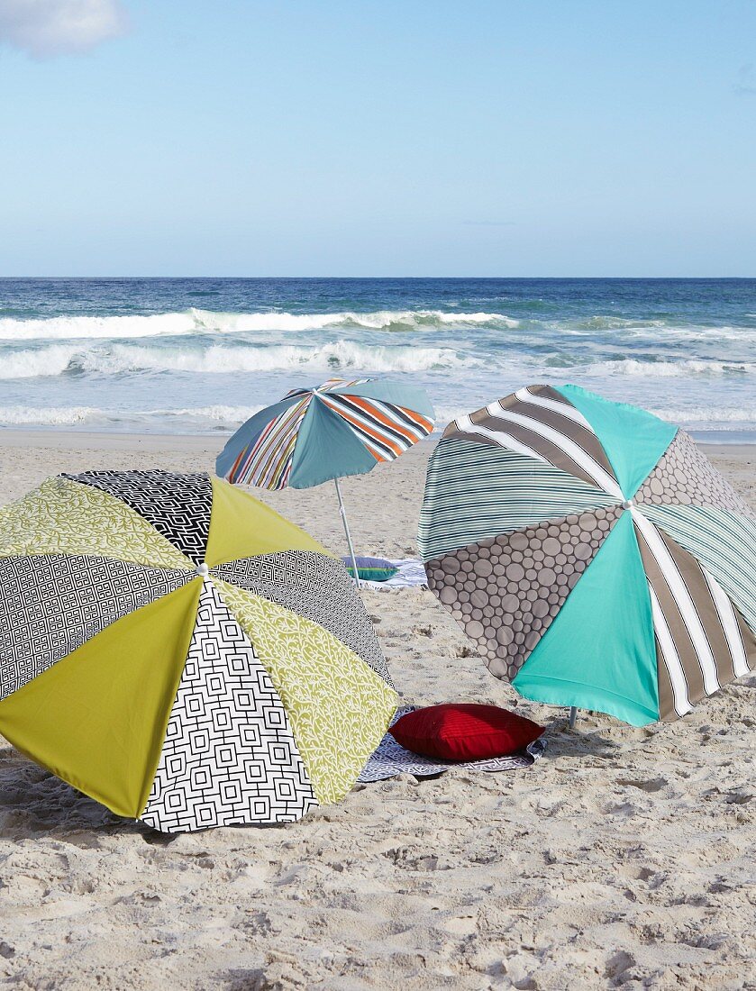 Schatten spendende Designer-Sonnenschirme im Sand am Meer