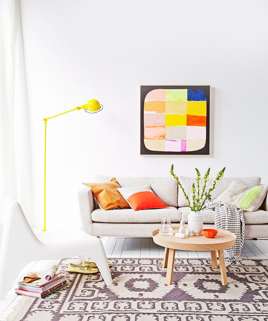 Sitzecke in Naturtönen, aufgefrischt durch gelbe Stehlampe und leuchtendes Gemälde an der Wand