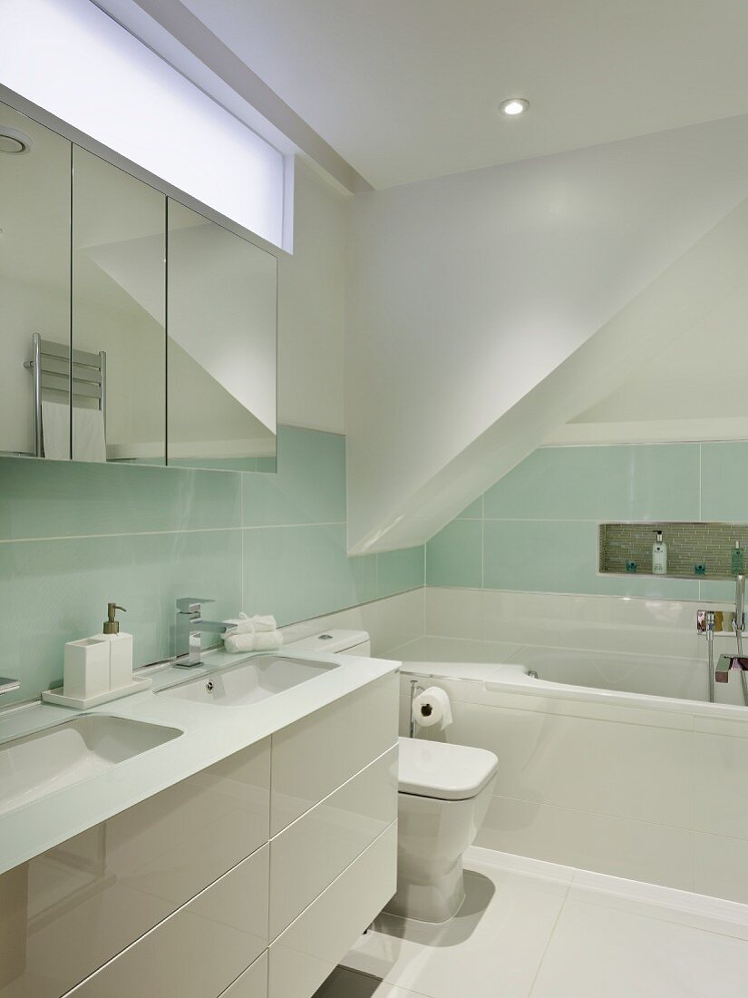 Designer Bad mit weißem Waschtisch vor pastellfarbenen Wandfliesen