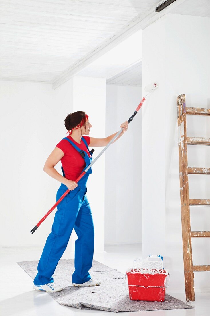 Woman painting wall with roller