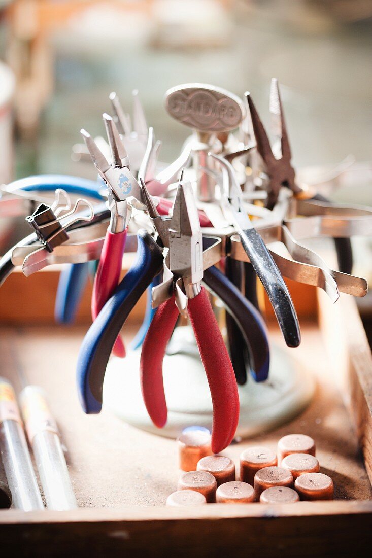 Collection of various jewellers' pliers on old-fashioned metal frame