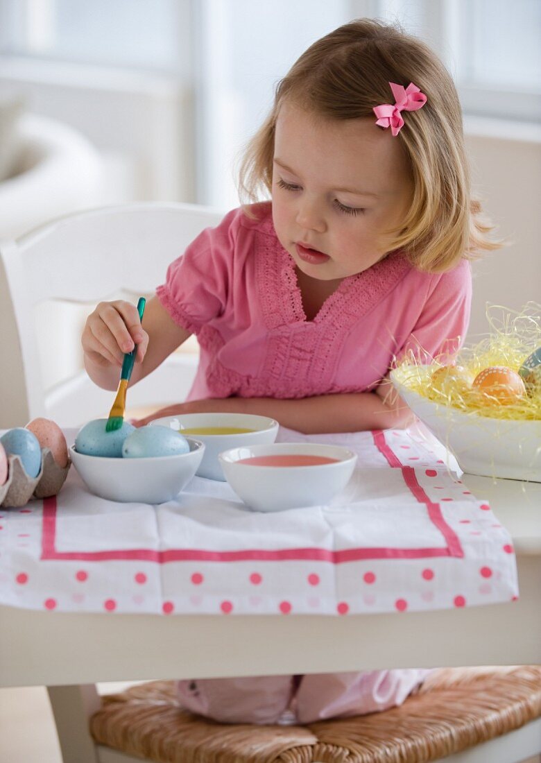 Young girl decorating eggs