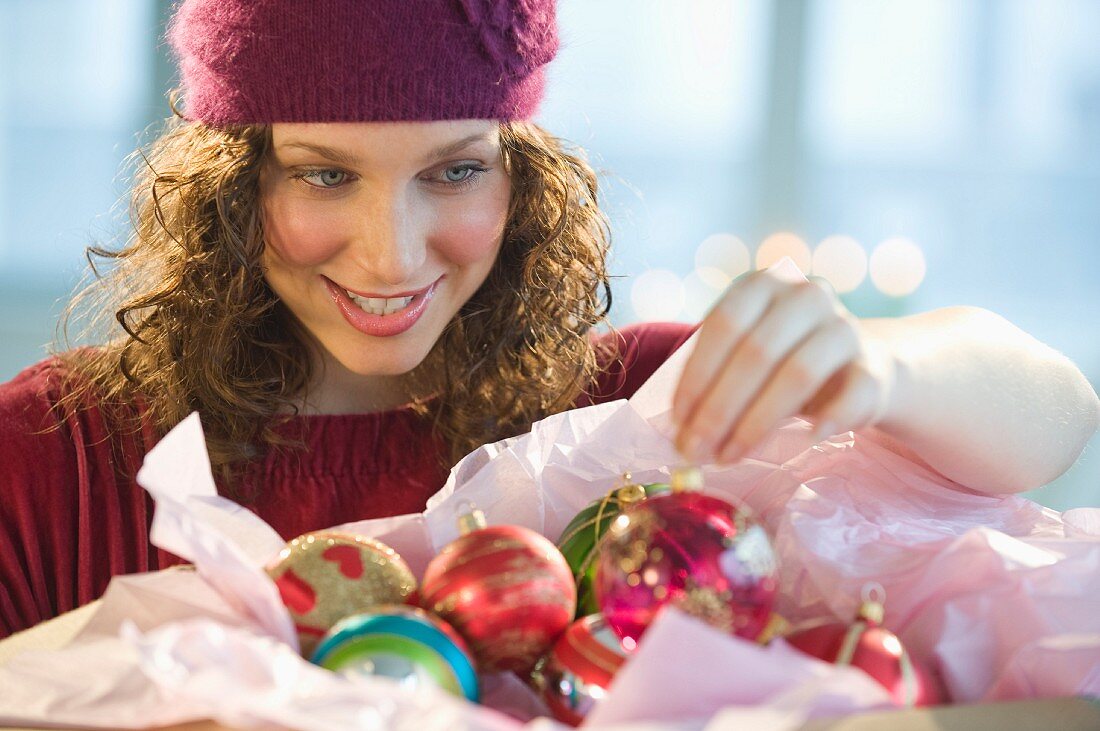 Frau packt Weihnachtsschmuck aus