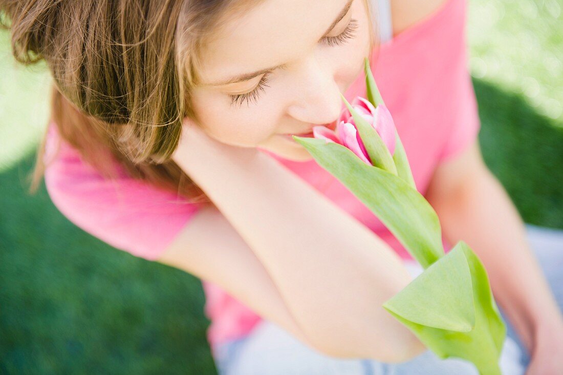 Frau riecht an einer Tulpe