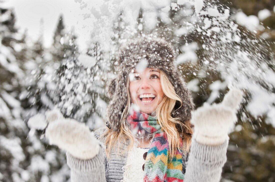Junge Frau spielt im Schnee
