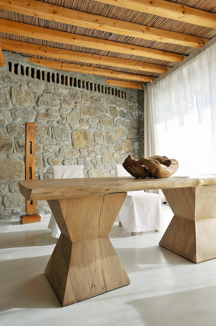 Rustic wooden table in front of stone wall
