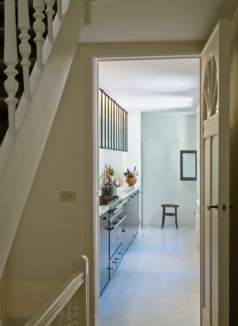 Blick vom Treppenhaus durch die offene Küchentür und Blick auf moderne Küchenzeile