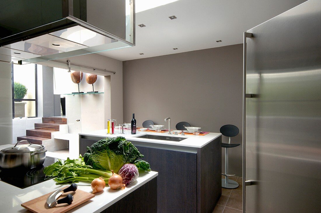 Vegetables on counter below extractor hood in designer kitchen decorated in various shades of grey