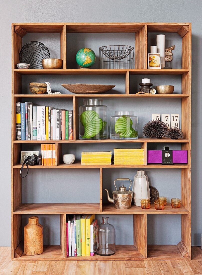 Ornaments and books on exotic wood shelving with compartments of various sizes