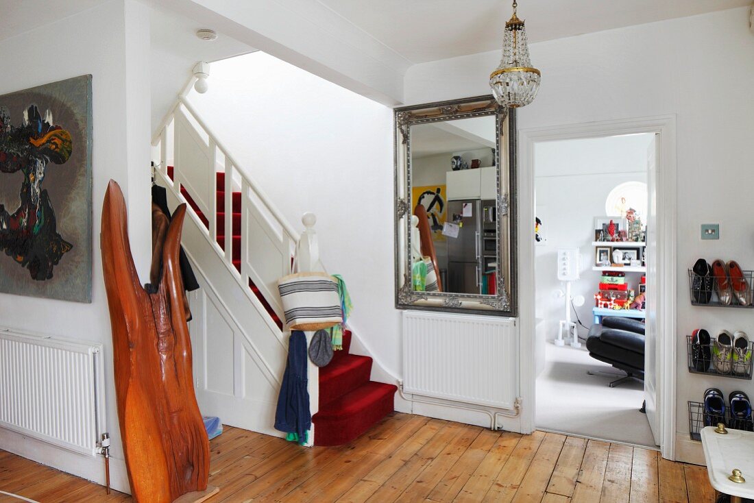 Treppe mit rotem Teppichbelag in tradionellem Vorraum mit Holzdielenboden
