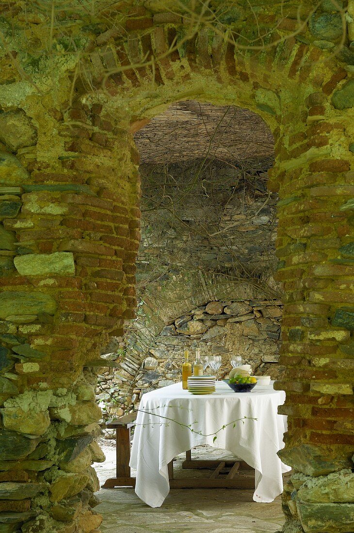 Secluded dining area in stone vaulted room with old church pew