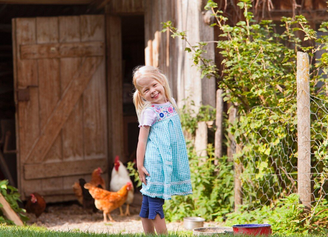 Germany, Bavaria, Girl with chicken on farm