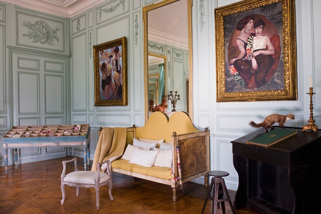Antike Sitzbank und Kleinmöbel in herrschaftlichem Salon mit Gemälden auf bemalter Holzpaneelwand