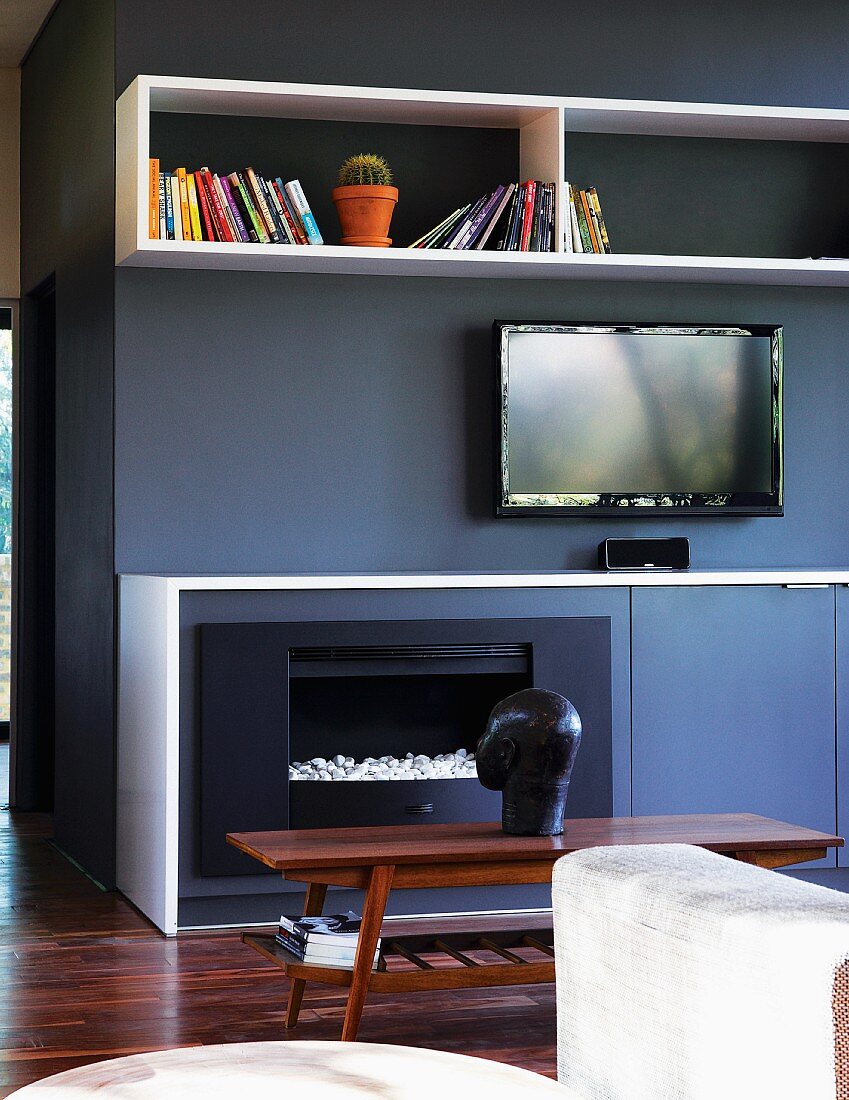 Fitted units in anthracite and white with integrated fireplace, sideboard, shelves and TV opposite sofa