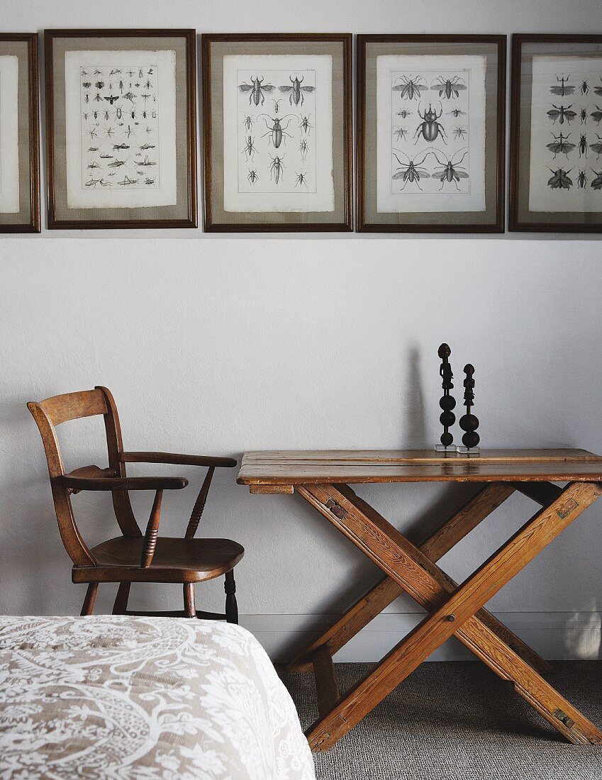 Gerahmte Insektenzeichnungen an weisser Wand mit darunterstehendem Vintage Tisch und Stuhl