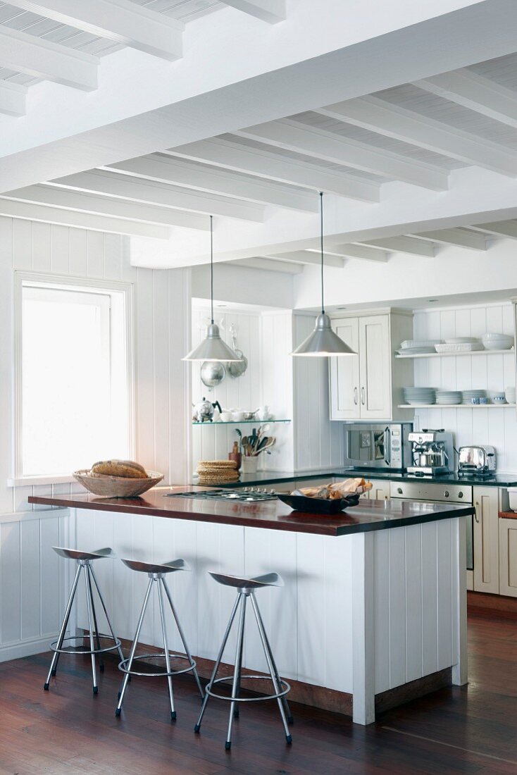 White kitchen with white, wood-beamed ceiling and dark brown parquet floor