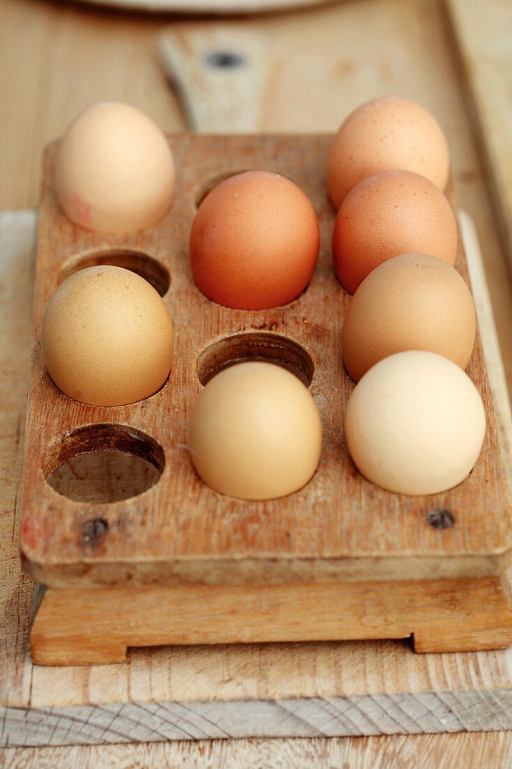 Hellbraune Eier in Vintage Eierbehälter aus Holz