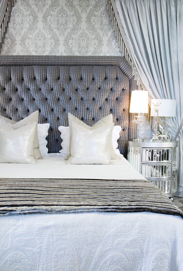 Elegant double bed with quilted headboard and silvery-grey canopy