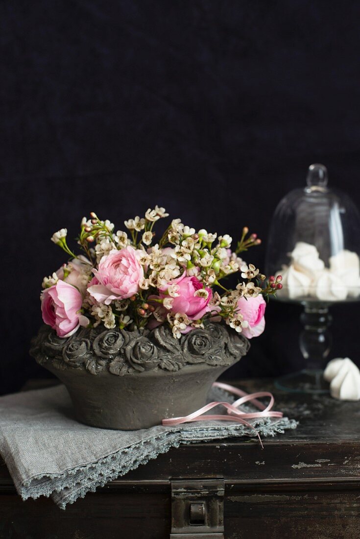 Blumenbouquet mit Rosen in einer romantischen Steinschale