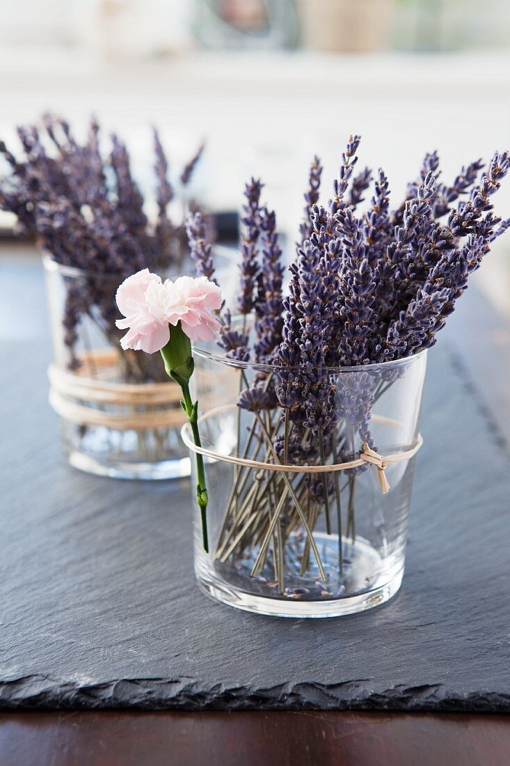 Sprays of lavender flowers in glass holders as table decorations