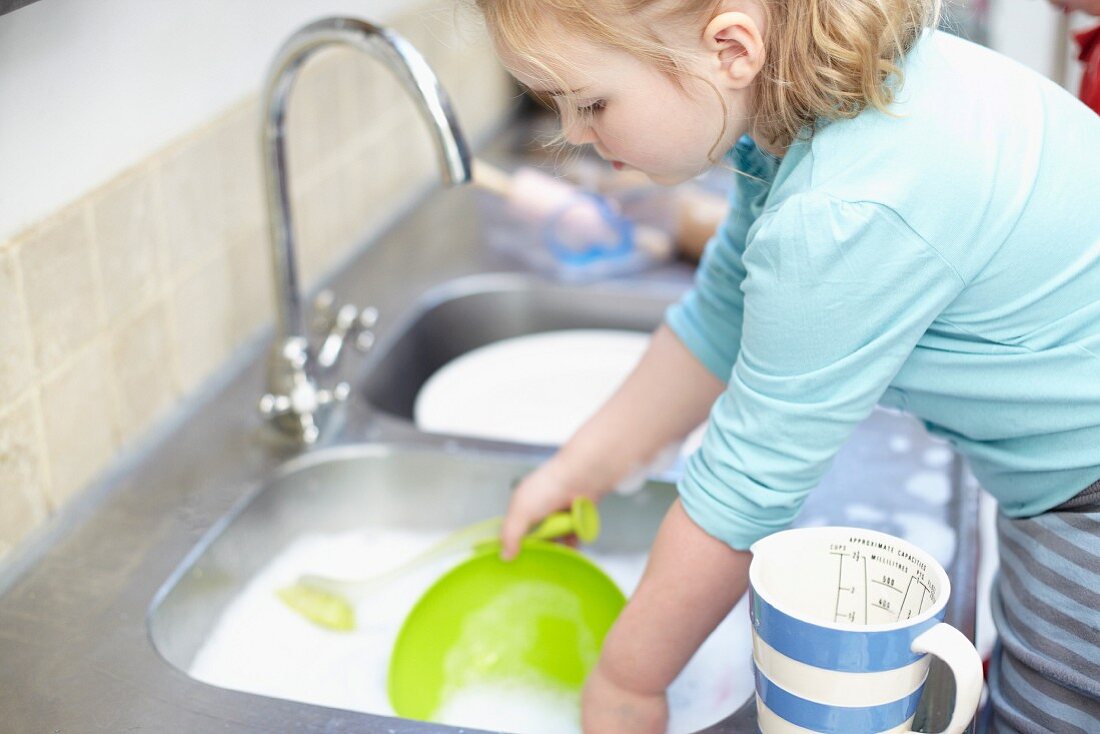 A girl washing up in the kitchen