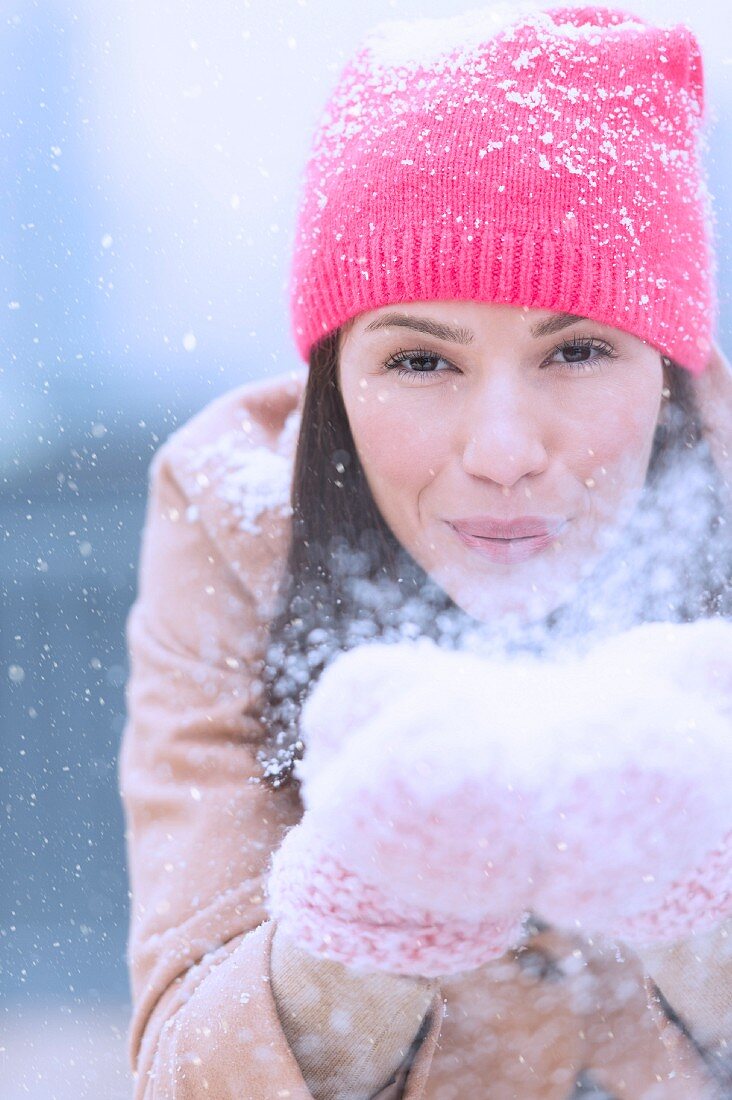 Woman blowing snow off hands