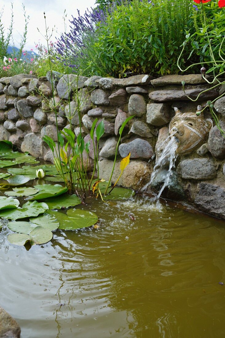 Wasserbecken aus Naturstein mit Terrakotta-Tierkopf als Wasserspeier
