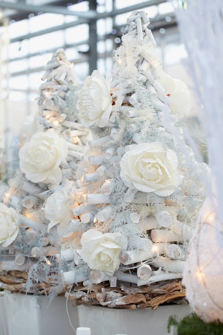 Weihnachtsbaum aus weißem Holz mit Rosenblüten und Lichterkette