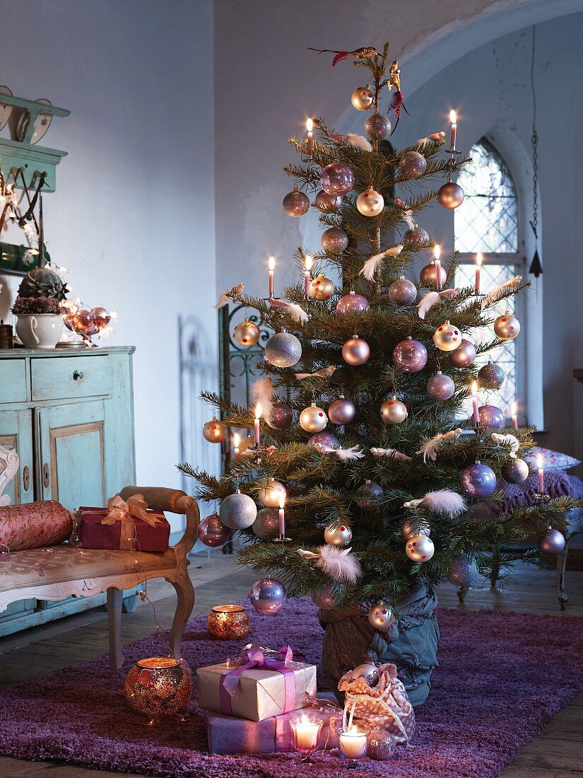 Dekorierter Weihnachtsbaum und Geschenke auf Boden im Wohnraum einer Landhausvilla