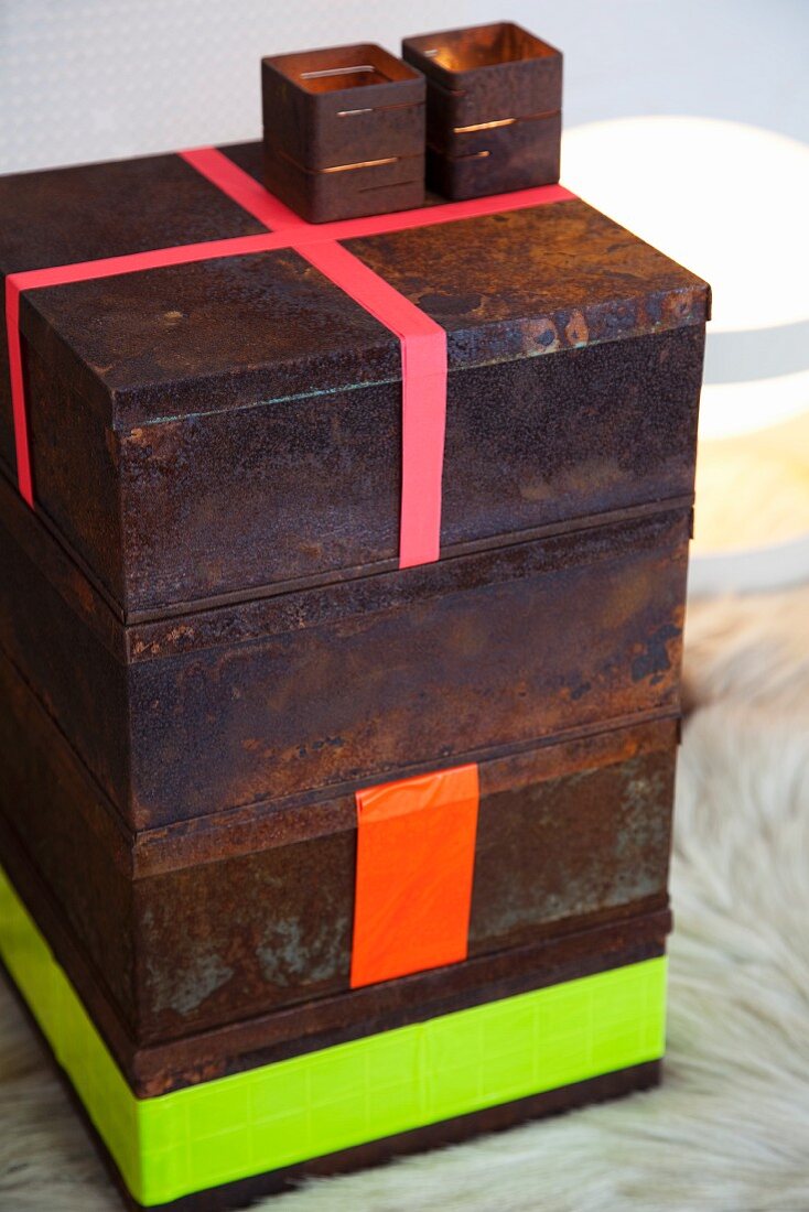 Stack of rusty tins with neon stripes