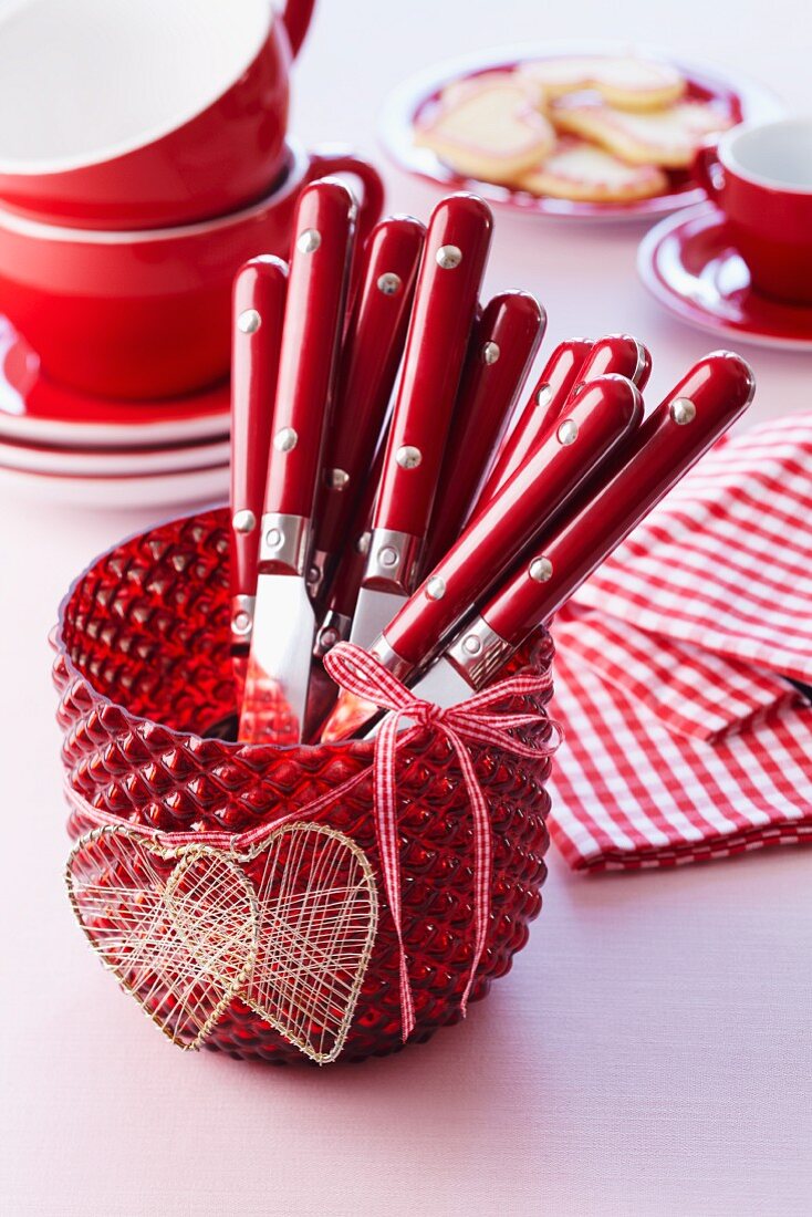 Red candle lantern with heart-shaped decorations used as cutlery holder