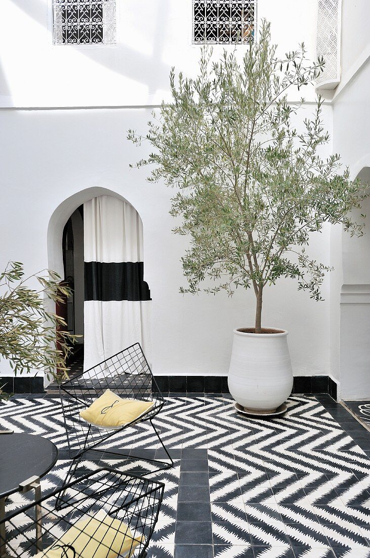 Tiled floor with black and white, graphic pattern in Moroccan courtyard
