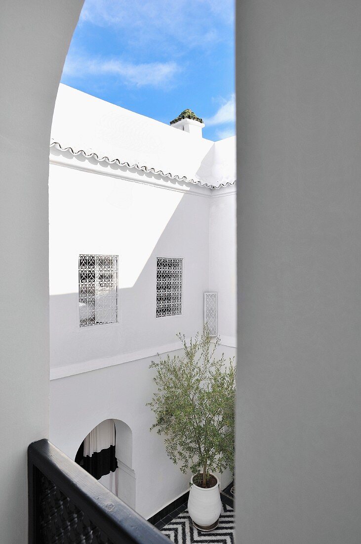 Blick von Balkon auf die Fassade eines marokkanischen Innenhofs und ein Stück blauen Himmels