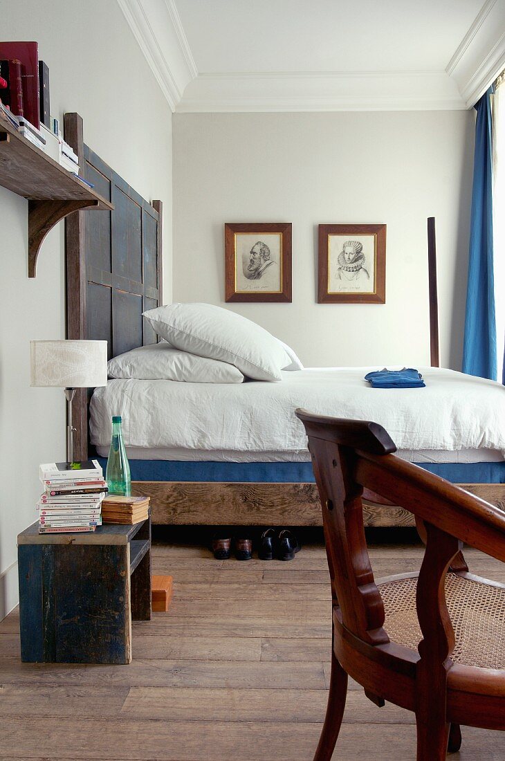 Rustikales Doppelbett mit Holz Kopfteil in Schlafzimmer mit Stuckfries an Decke