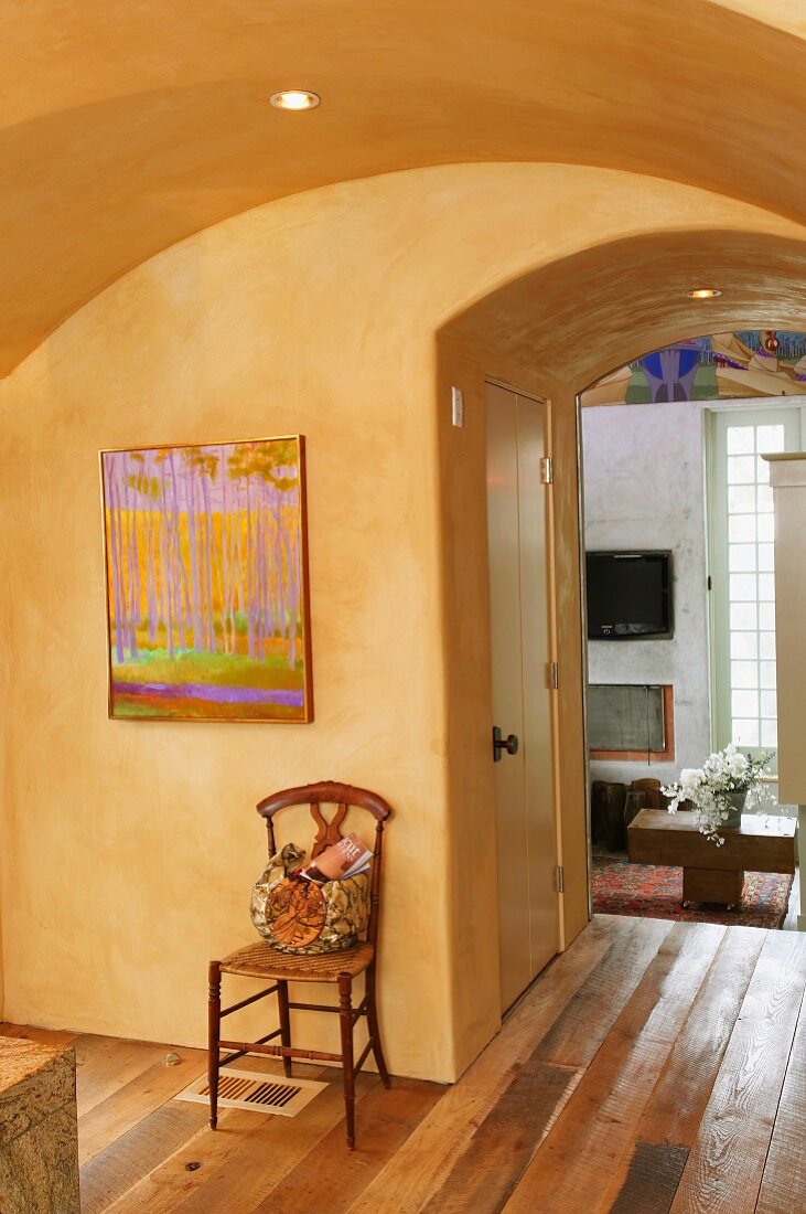 Foyer with yellow-painted vault and view into living room through ceiling-high open doorway
