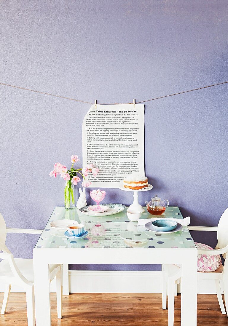 Refurbished old table: glass top with window transfers and printed page hung on lavender wall