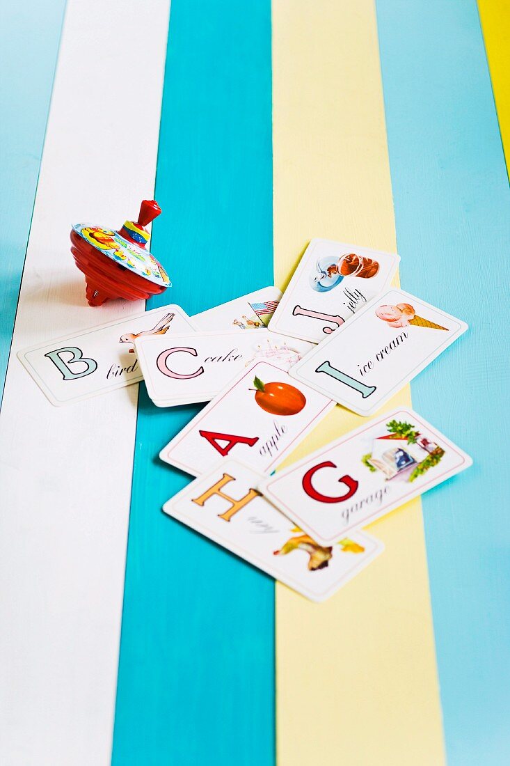 Top and alphabet cards on a wooden crate painted with a variety of colors