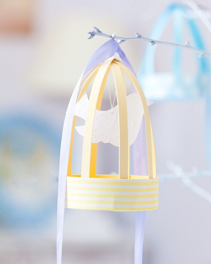 Paper bird cage on white twig