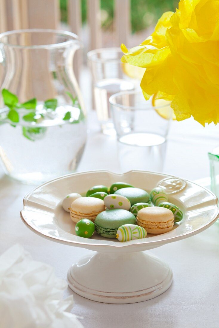 Macaroons and brightly coloured eggs on an Easter table