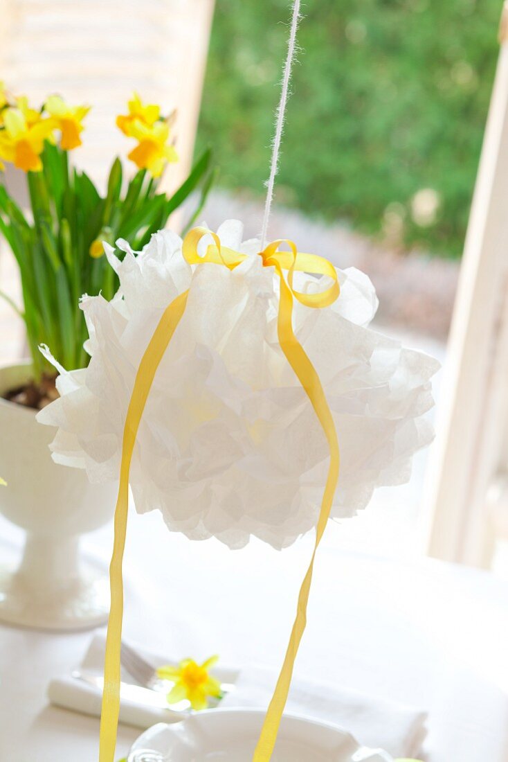 White pompom hanging over set Easter table