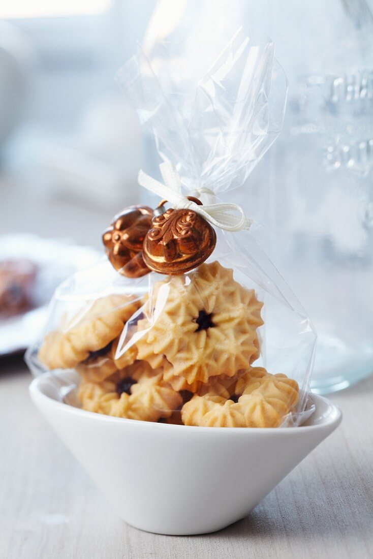 Small bags of biscuits decorated with miniature cake moulds as guest favours