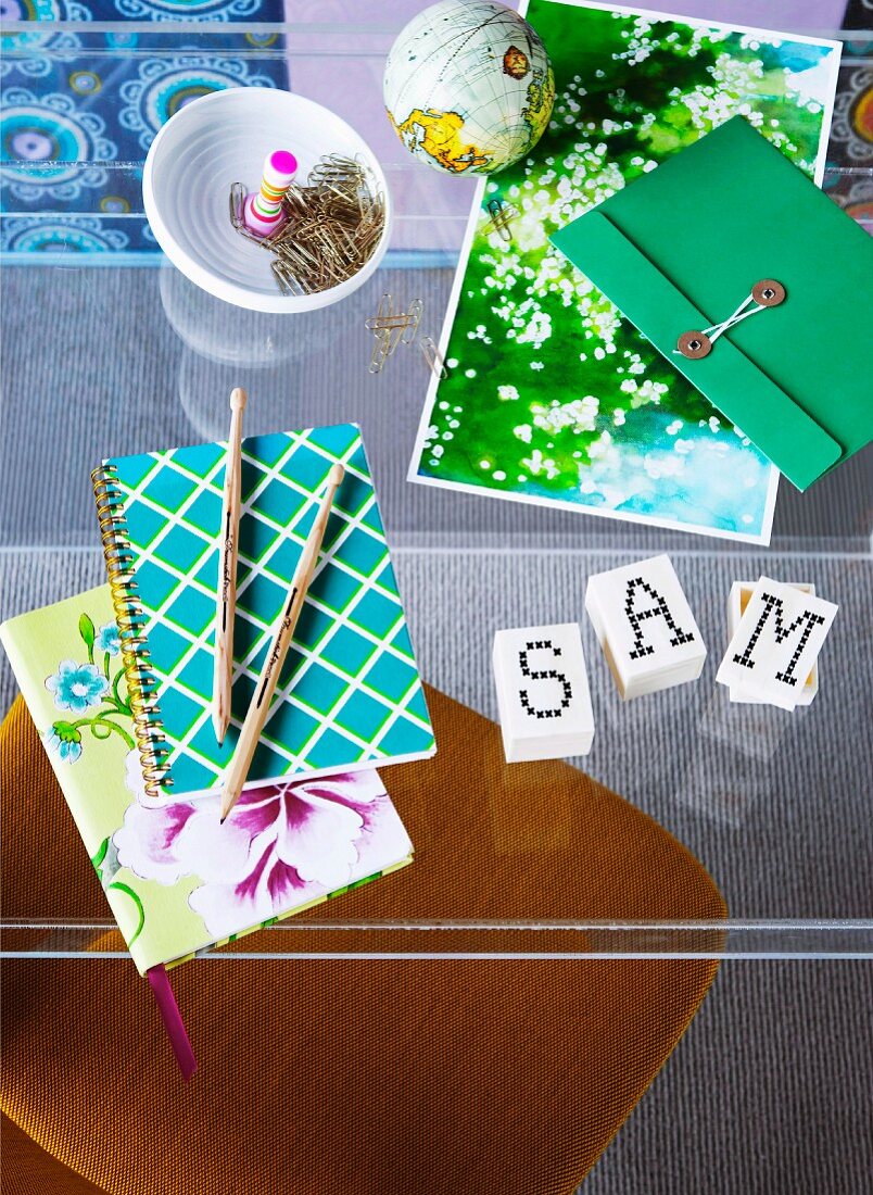 Stationary, alphabet cubes and notebooks on glass table
