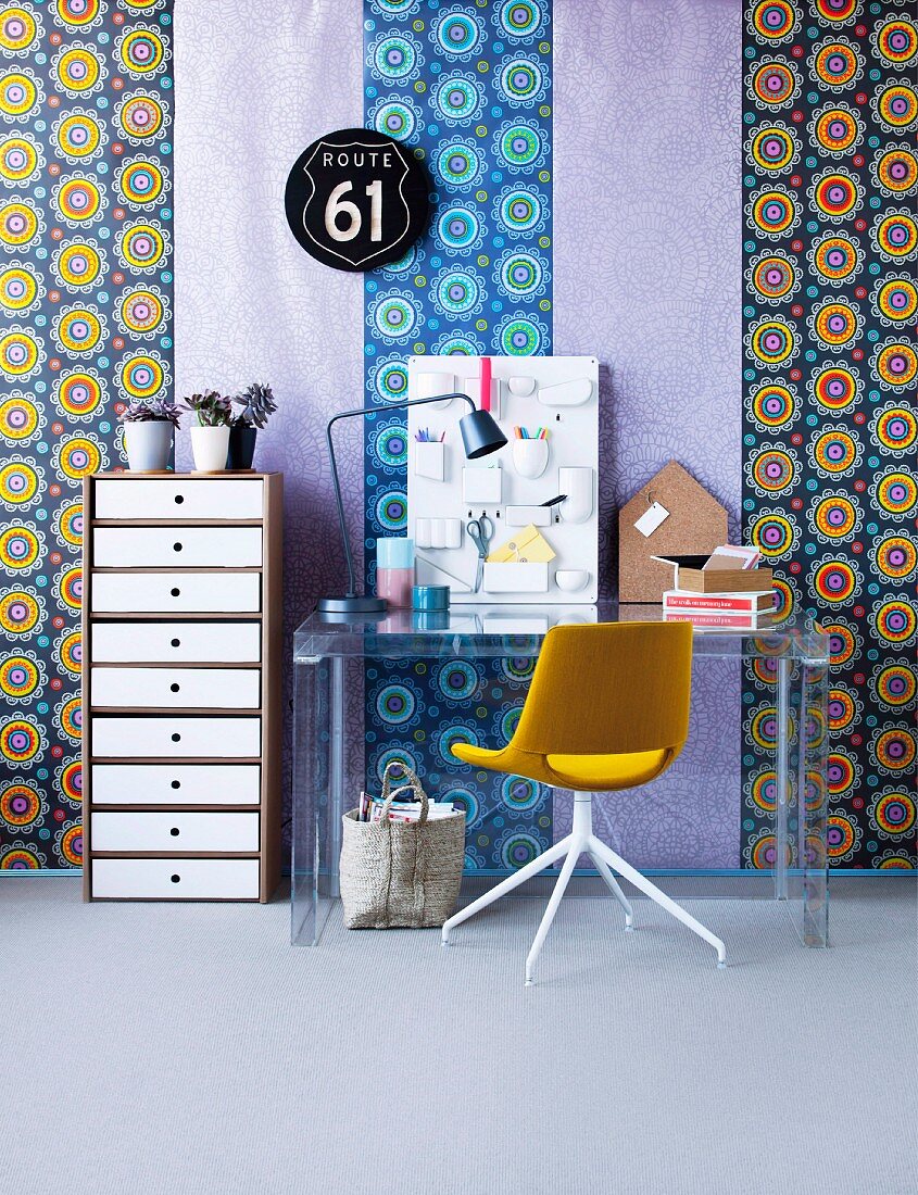 Kräftig gemusterter Tapetenmix als Hintergrund für modernen Schreibplatz mit neutralem Schubladenturm, Acrylglastisch und Drehstuhl