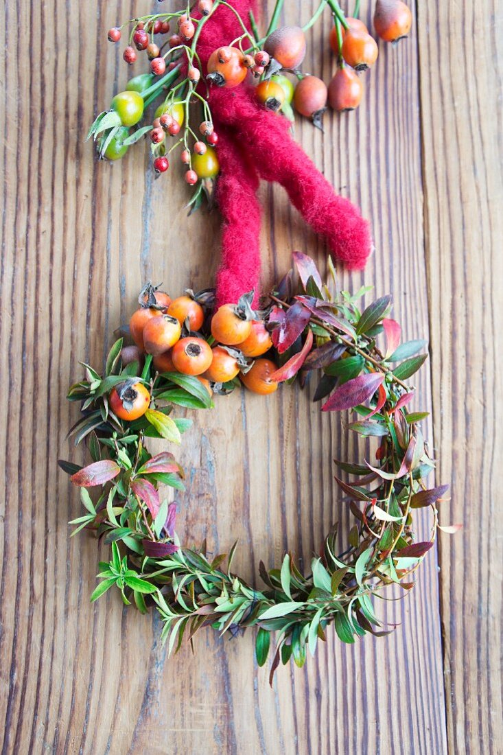 Wreath of spirea twigs and rosehips with felt cord on wedding reception table