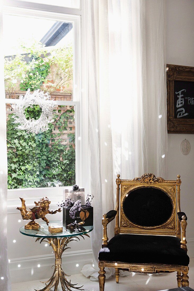 Vergoldeter Armlehnstuhl im Renaissance Stil und weihnachtlich dekorierter Beistelltisch aus Glas mit Fuss aus stilisiertem Blattwerk