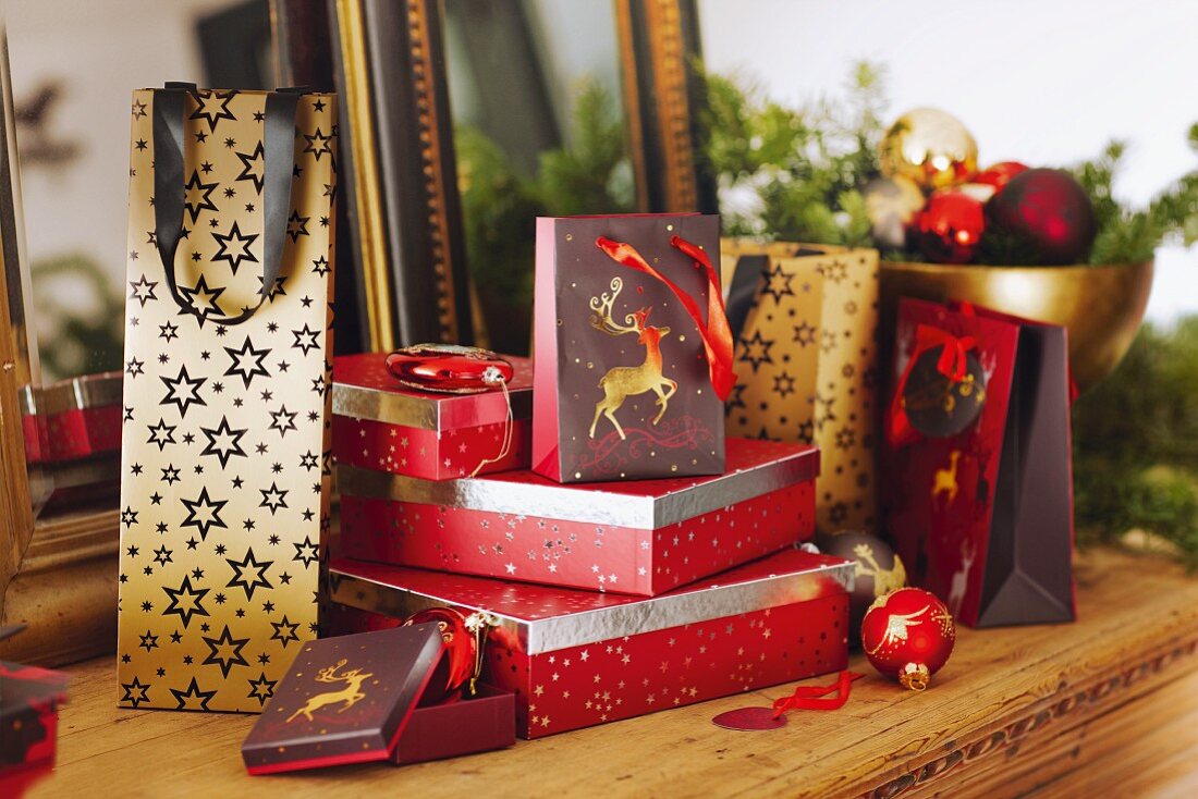 Wrapped presents, gift bags and baubles on rustic wooden table