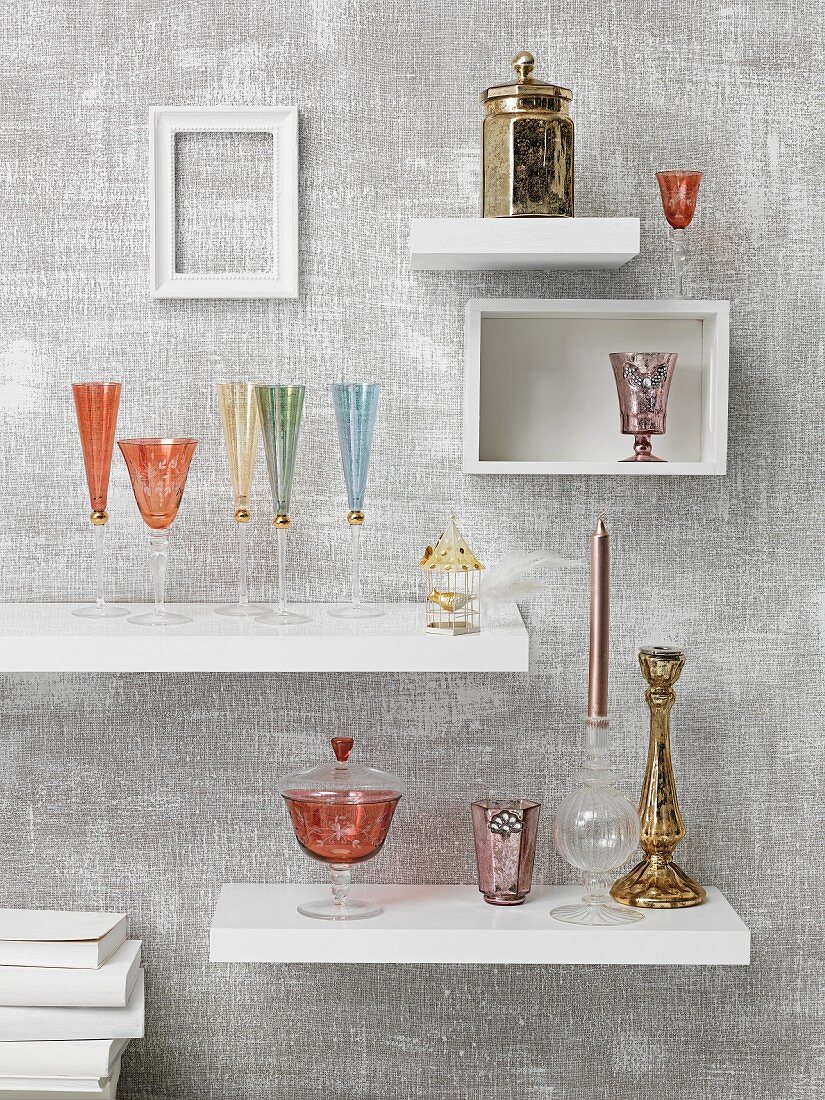 Glasses on white shelving units mounted on grey wall