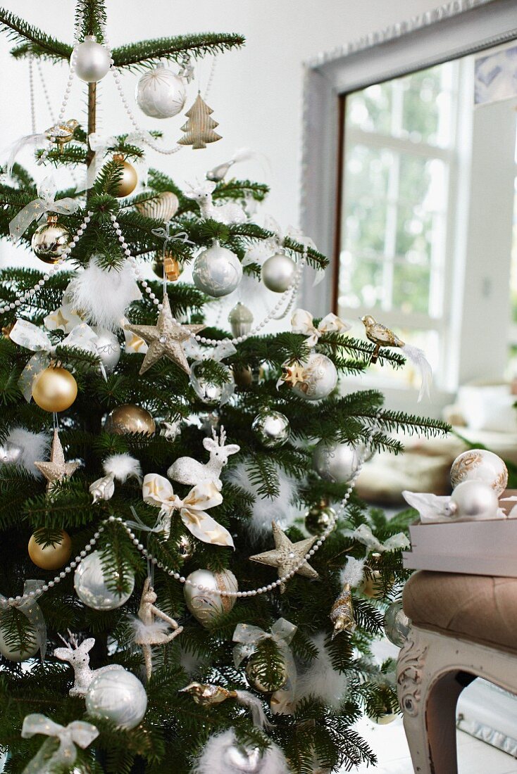 Üppig geschmückter Weihnachtsbaum im Wohnzimmer